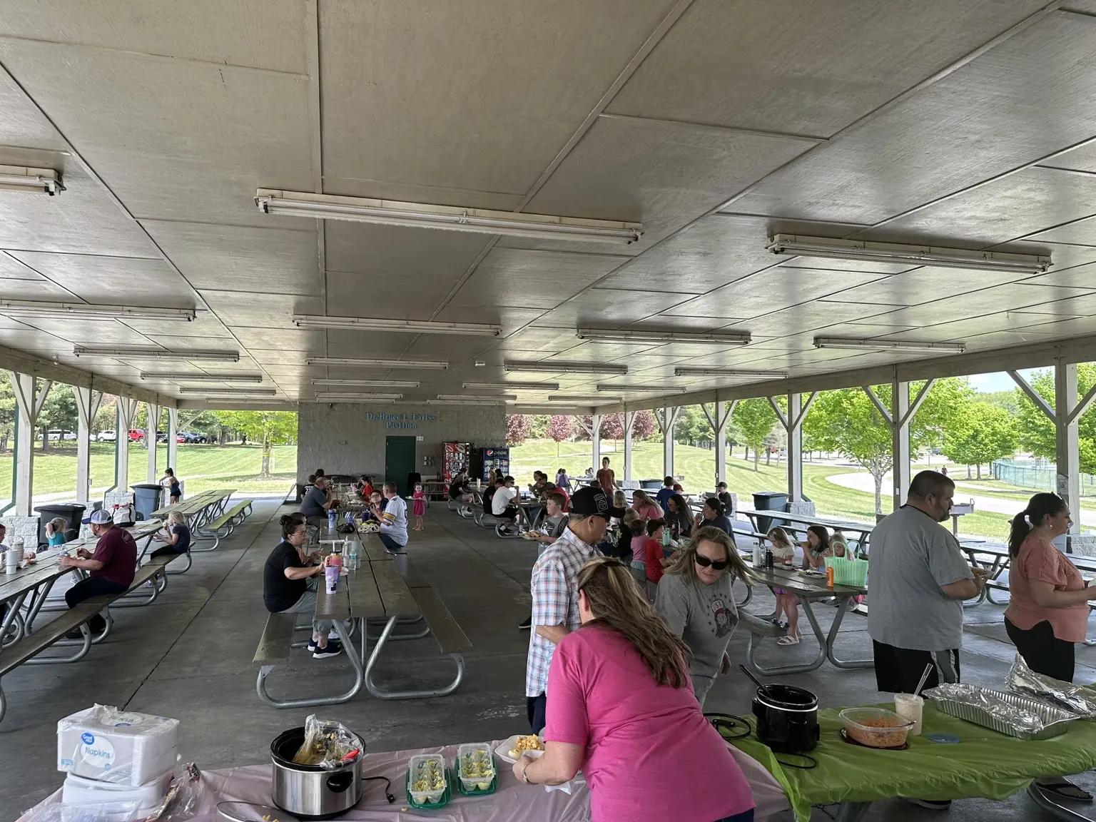 Church families sharing a community picnic under a pavilion